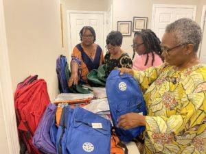 volunteers fill backpacks with supplies