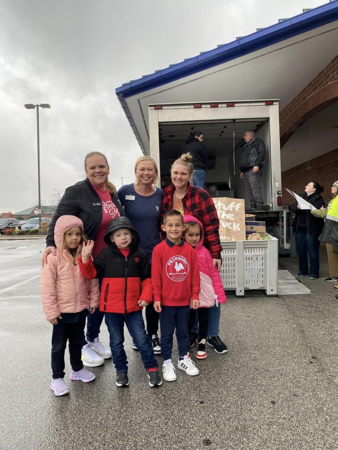 A family posing for a picture at a food drive.
