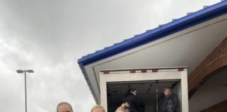 A family posing for a picture at a food drive.