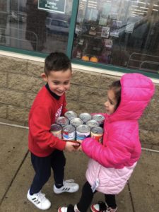 Children carrying food products that will be donated.