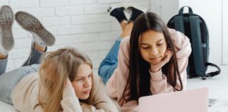 Two people watching something on a laptop.