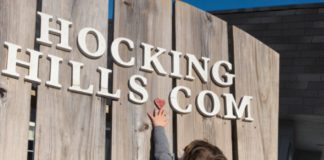 A child playing near a Hocking Hills sign.