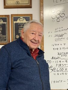 A person standing by a white-board.