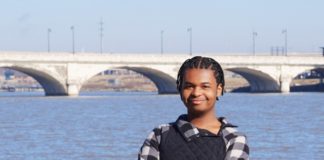 A person standing by a bridge.