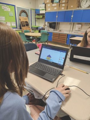 A kid playing on a computer.