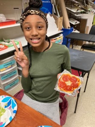 A child holding art they created.