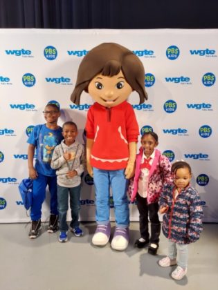 Kids standing by a mascot.