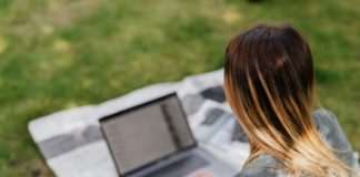Someone working on a computer outside.