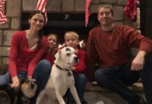 Two people sitting with a dog.