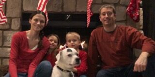 Two people sitting with a dog.