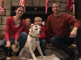 Two people sitting with a dog.