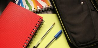 Notebooks and pens laying on a desk.