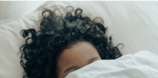 A person covering her face in a blanket.