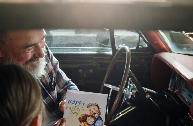Father and daughter looking at a card
