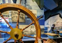 A photo of a child next to a large wheel.