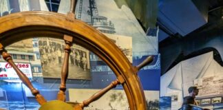 A photo of a child next to a large wheel.