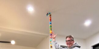 Father and sons displays their tall lego building