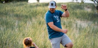Father playing with son in a green field