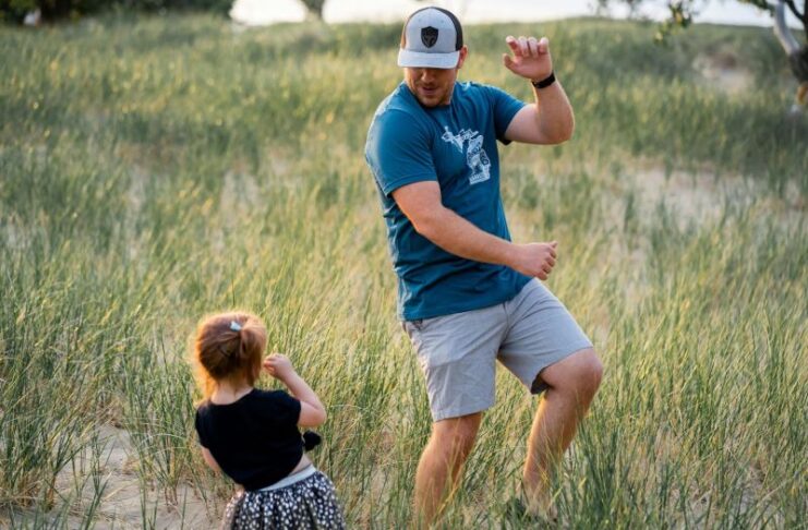 Father playing with son in a green field