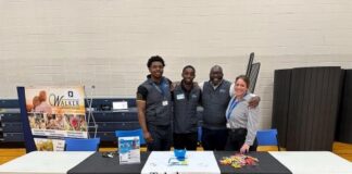 People standing behind a table.