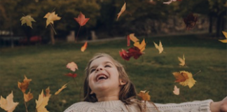 Young girl playing the falling leaves