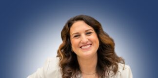 Woman standing in white jacket against blue background