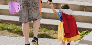 Man holding hand with girl in snow white costume