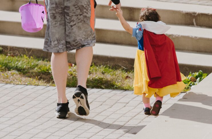 Man holding hand with girl in snow white costume