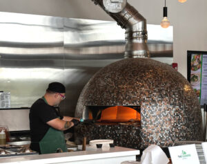 Man cooking pizza in pizza oven