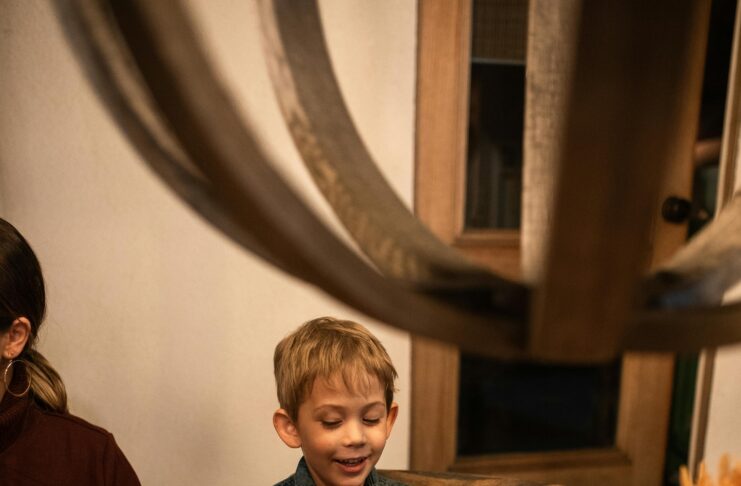 Young boy passing plate at dinner table