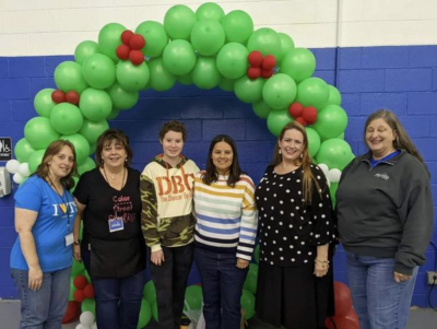 Group of 6 in front of balloon arch