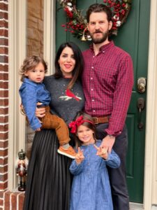 Family of four in front of green door