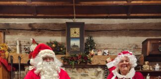 Santa and Mrs. Claus in chairs in cabin