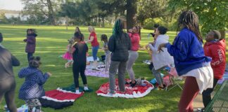 Group of parents and kids on blankets in park