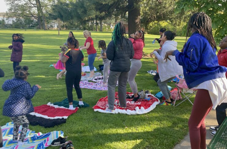 Group of parents and kids on blankets in park