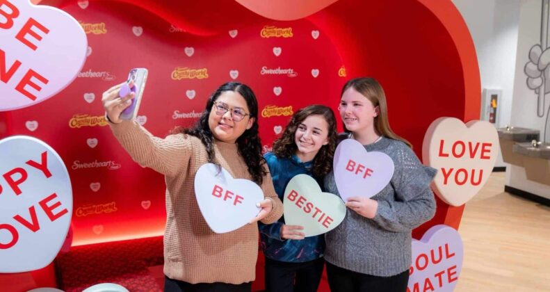 Three girls taking selfie with candy hearts