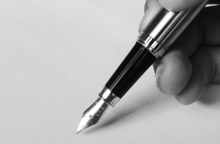 Black and white photo of pen and paper