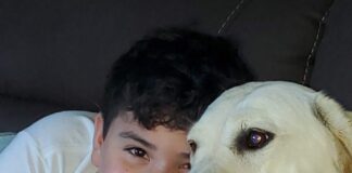 Boy cuddling with dog