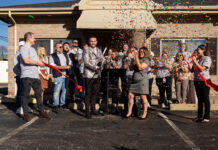 Ribbon cutting with large group and confetti