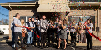 Ribbon cutting with large group and confetti