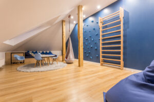Spacious blue and white children room with climbing wall and bean bag