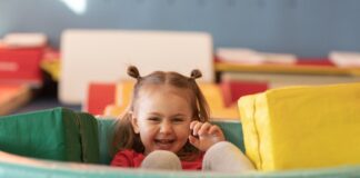 Little girl playing with soft mats and blocks