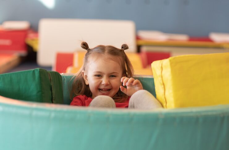 Little girl playing with soft mats and blocks