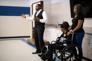 man speaking in presentatoin next to two women