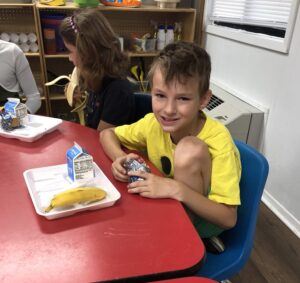 kid eating meal on tray