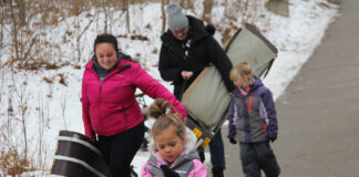 Family holding toboggan sleds