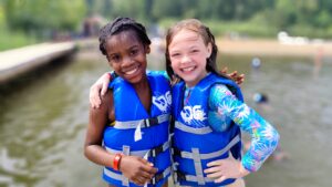 girls wearing life vests and smiling