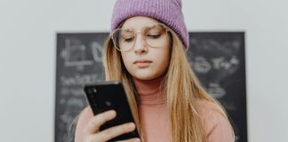 Teen girl in hat looking and smart phone